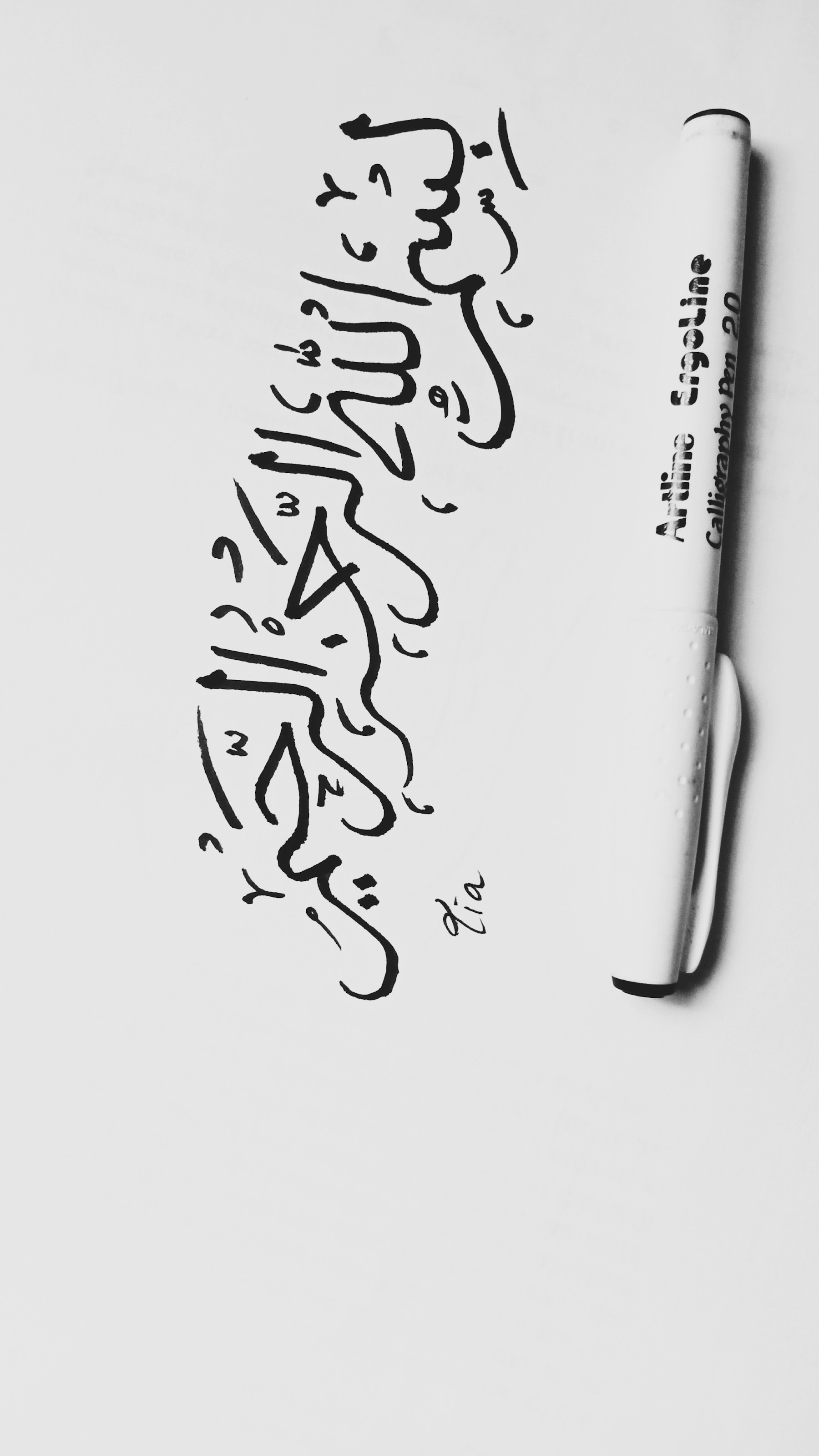 يد تكتب حروفًا عربية بالحبر